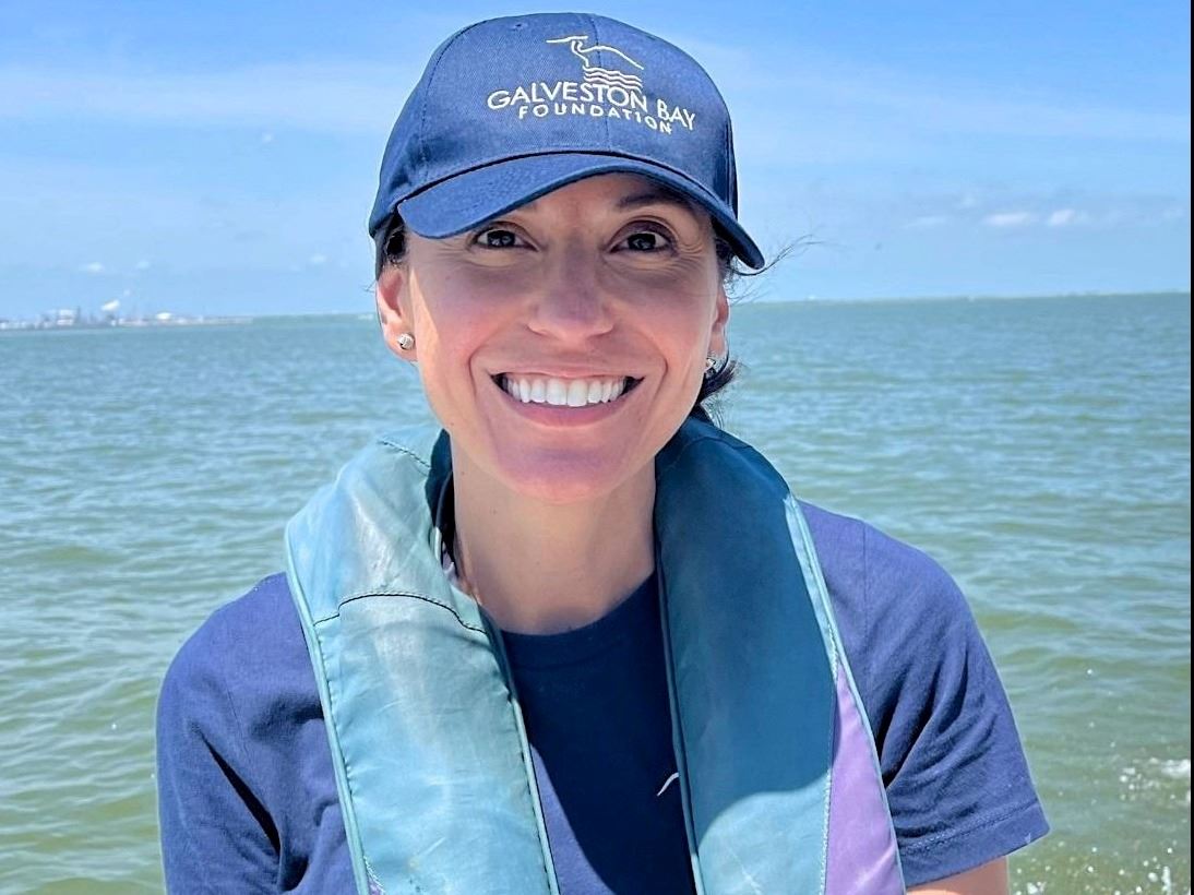 Professional headshot of a young lady outside wearing a blue hat