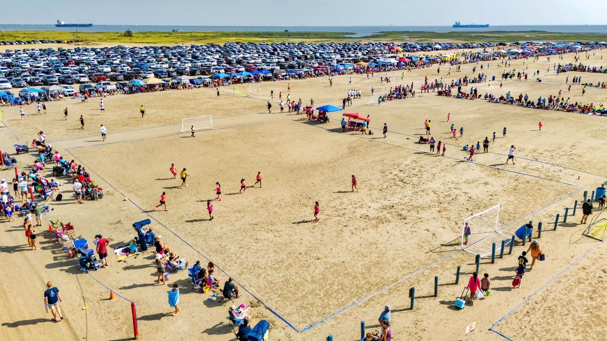 Overhead view of kids playing soccer on the beach